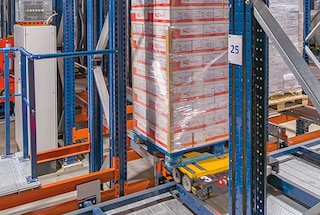 Un shuttle 4-Way agarra el pallet y comienza su recorrido